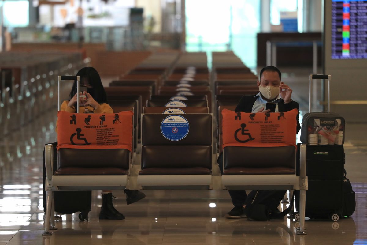 People wearing face masks wait for boarding at the Noi Bai airport in Hanoi, Vietnam, Friday, Feb.12, 2020. Fresh COVID-19 outbreak in Vietnam has slowed down business and travel during the popular lunar new year festival. (Hau Dinh)