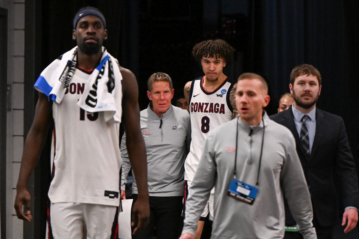 Gonzaga Bulldogs head coach Mark Few puts his arm around guard Jalen Warley (8) as they and forward Graham Ike (15) walk to a press conference after falling to the Texas Longhorns during the second half of the second round of the NCAA basketball tournament on Saturday, Mar 21, 2026, at Moda Center in Portland, Ore. The Texas Longhorns won the game 74-68.  (Tyler Tjomsland / The Spokesman-Review)