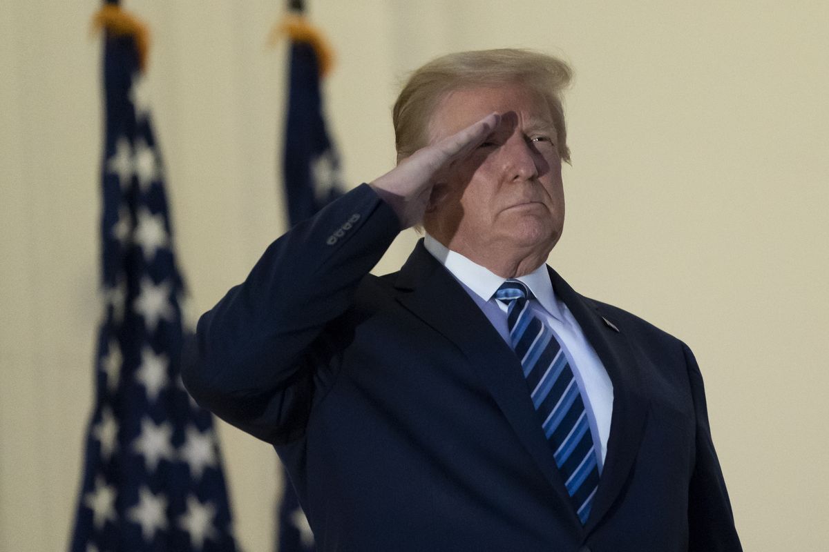 President Donald Trump salutes as he stands on the Blue Room Balcony upon returning to the White House Monday, Oct. 5, 2020, in Washington, after leaving Walter Reed National Military Medical Center, in Bethesda, Md. Trump announced he tested positive for COVID-19 on Oct. 2.   (Alex Brandon/Associated Press)