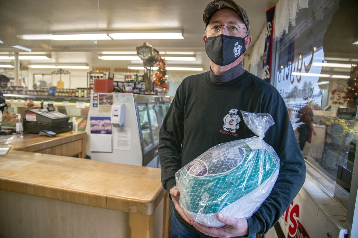 Owner Greg Traband hold one of Egger’s Meats North’s fresh turkeys for the holiday at Egger’s Meats North in North Spokane, Monday, Nov. 23, 2020. Traband has to inquirers that the shop has sold out of fresh turkeys but if there is a cancellation, he can sell those to buyers who forgot to pre-order them up to a month in advance.  (Jesse Tinsley/The Spokesman-Review)
