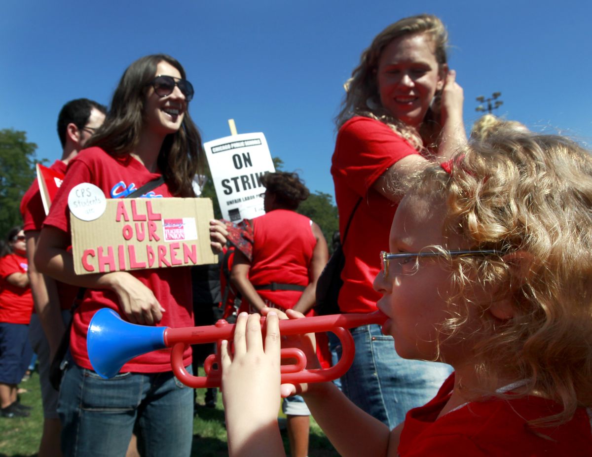 A young girl plays a toy horn as striking Chicago teachers rally Saturday, Sept. 15, 2012, in Chicago. Union president Karen Lewis reminded that although there is a "framework" for an end to their strike, they still are on strike. (Sitthixay Ditthavong / Fr170753 Ap)