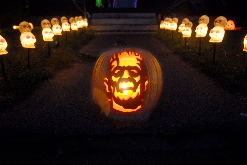 Curtis Wilkes displays one of his many pumpkin carvings outside his home in Spokane. (Photo Archive / The Spokesman-Review)