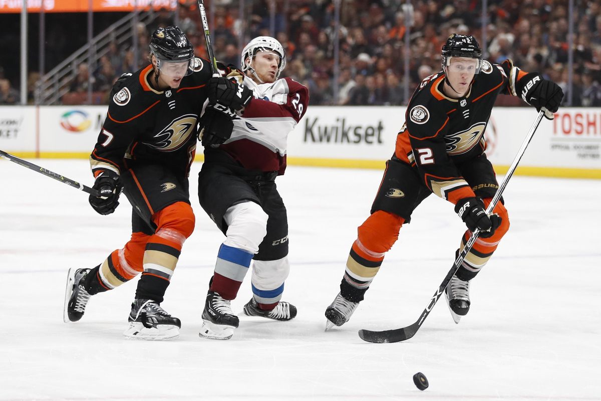 Anaheim Ducks’ Josh Manson, right, chases the puck as Colorado Avalanche’s Nathan MacKinnon, center, is shoved by Ducks’ Hampus Lindholm, of Sweden, during the first period of an NHL hockey game Sunday, April 1, 2018, in Anaheim, Calif. (Jae C. Hong / Associated Press)