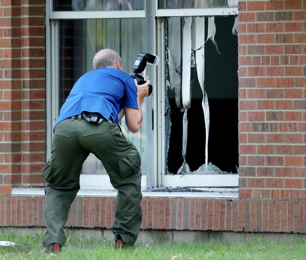 A law enforcement official photographs the scene of an early morning explosion Saturday, Aug. 5, 2017, at the Dar Al-Farooq Islamic Center in Bloomington, Minn. (David Joles / Tribune News Service)