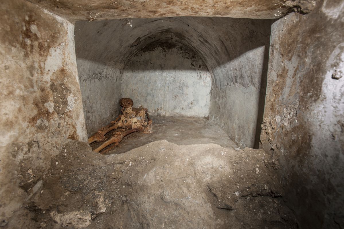 In this undated photo released by the Pompeii archeological park, a view of the tomb located in the necropolis of Porta Sarno, in an area not yet open to the public in the east of Pompeii’s urban center. Archaeologists in the ancient city of Pompeii have discovered a remarkably well-preserved skeleton during excavations that also shed light on the cultural life of the city before it was destroyed by a volcanic eruption in AD 79. The discovery is unusual since most adults were cremated at the time.  (Alfio Giannotti)
