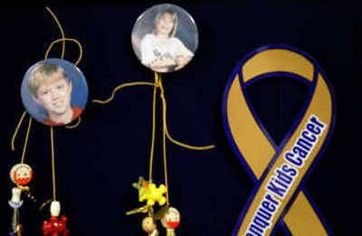 
On the bulletin board in her office are photos of children battling cancer including two of Ruddis' children (center buttons ) who lost their struggle with the disease.
 (The Spokesman-Review)