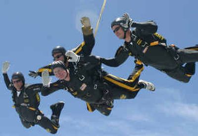 
Former President George H.W. Bush, lower center, waves as he parachutes in a tandem jump with Sgt. Bryan Schnell, a member of the U.S. Army Golden Knights on Sunday.
 (Associated Press / The Spokesman-Review)