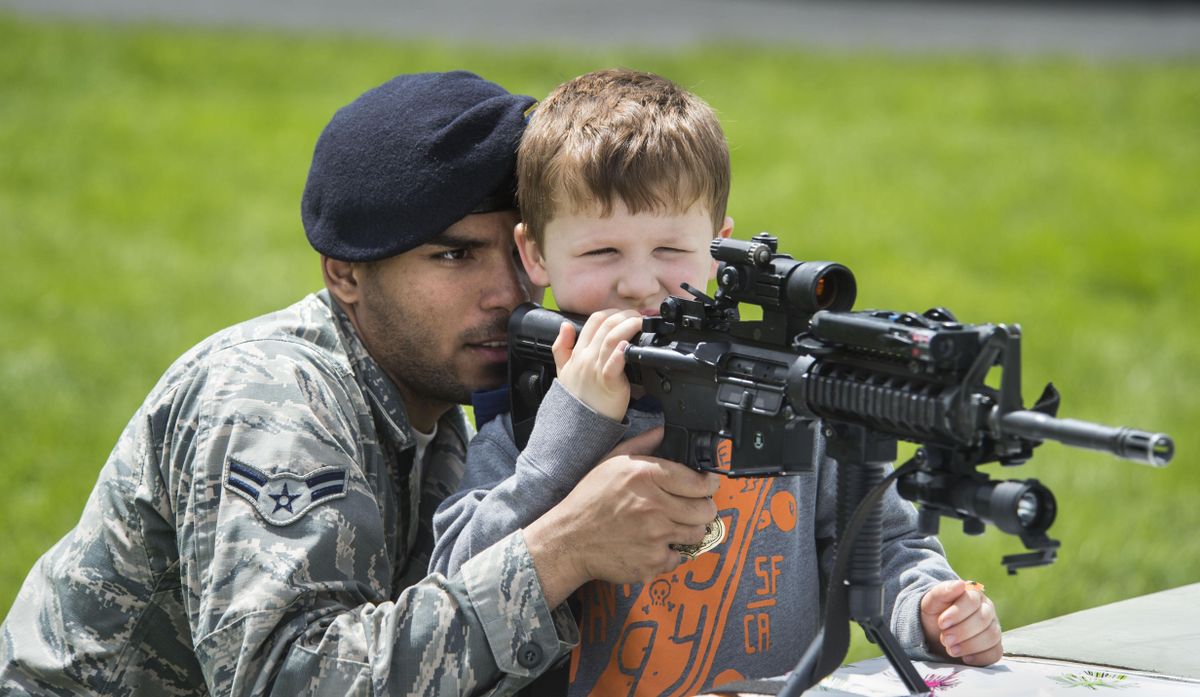 Fairchild security  Airman First Class Di’Amond Brown helps Colin Griffith, 5, aim the laser sight on an M4 carbine during demonstrations on the base as part of National Police Week, May 18, 2017. Tiffany Griffith said her son wants to be a police officer. (Dan Pelle / The Spokesman-Review)