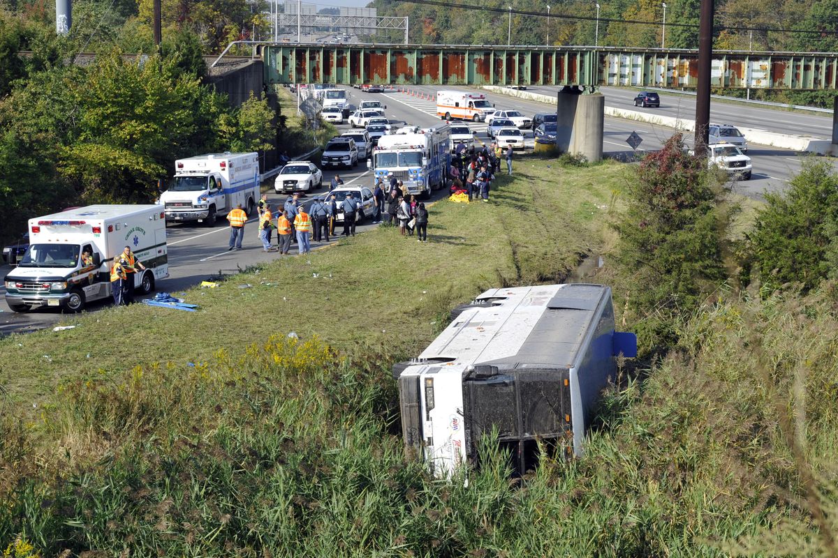 Rescue workers and passengers stand by after a bus overturned in a ditch at an exit ramp off Route 80 in Wayne, N.J. Saturday, Oct. 6, 2012. The chartered tour bus from Toronto carrying about 60 people overturned on an interstate exit ramp. Three people have been taken to hospital with non-life-threatening injuries. (Bill Kostroun / Fr51951 Ap)