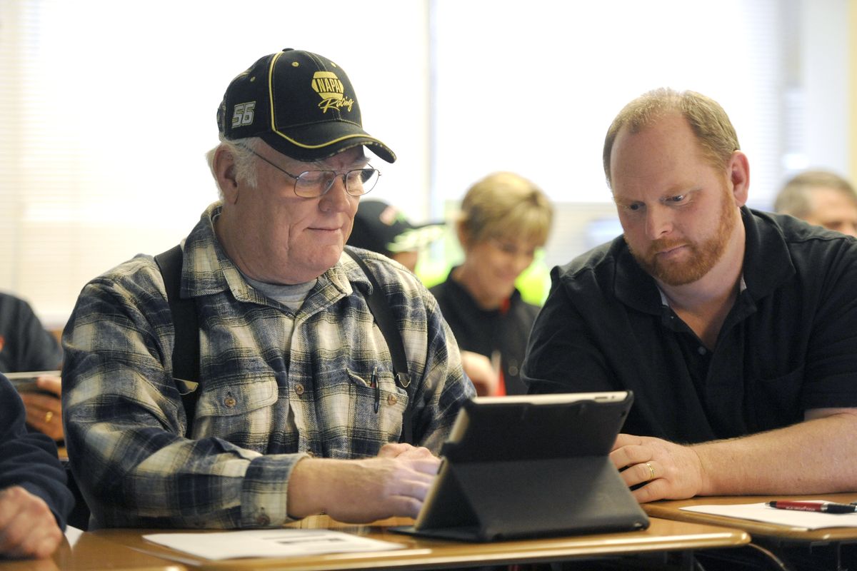 Neil Shearer, left, and John Jeffries, who work in maintenance for the West Valley School District, play with an iPad in a class at West Valley High on Tuesday. (Jesse Tinsley)