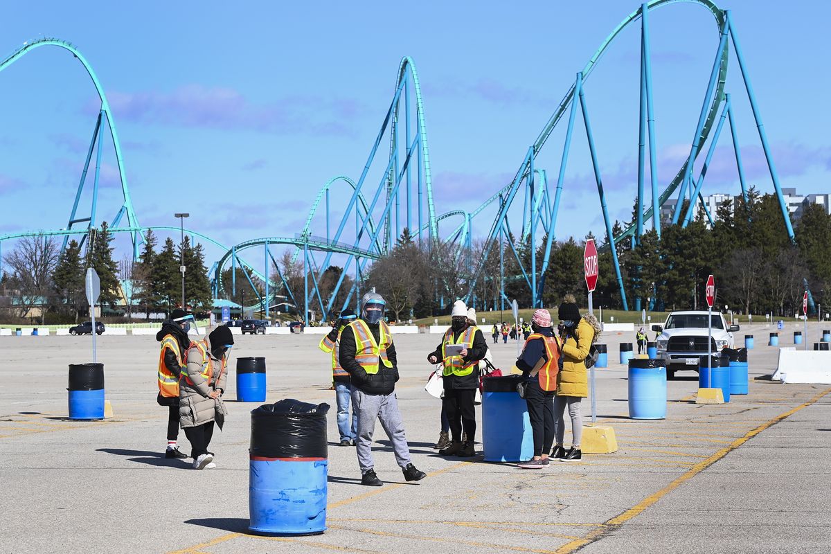 Health care workers prepare to take patients at a drive-thru COVID-19 mass vaccination site at Canada