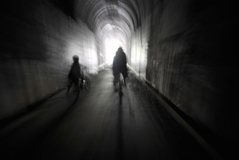 Bicyclists approach the end of the Taft Tunnel, the longest of several former railroad tunnels on the Route of the Hiawatha. The tunnel is more than a mile long. It’s dark, wet and spooky, and cyclists seem to love it. 