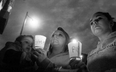 
Joyce Lockard, center, and her two children, Quentin and Corey, left and right, hold candles at a service  in the shadow of the apartment where 4-year-old Summer Phelps  lived. The Lockards did not know Summer, who died last week, but they had their own experiences with death through child abuse. 
 (Ingrid Lindemann / The Spokesman-Review)