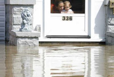 
A woman and a child look out at floodwaters approaching their door Wednesday in Findlay, Ohio. Flooding remained a problem in parts of northern Ohio, keeping streets closed and schools shut.Associated Press
 (Associated Press / The Spokesman-Review)