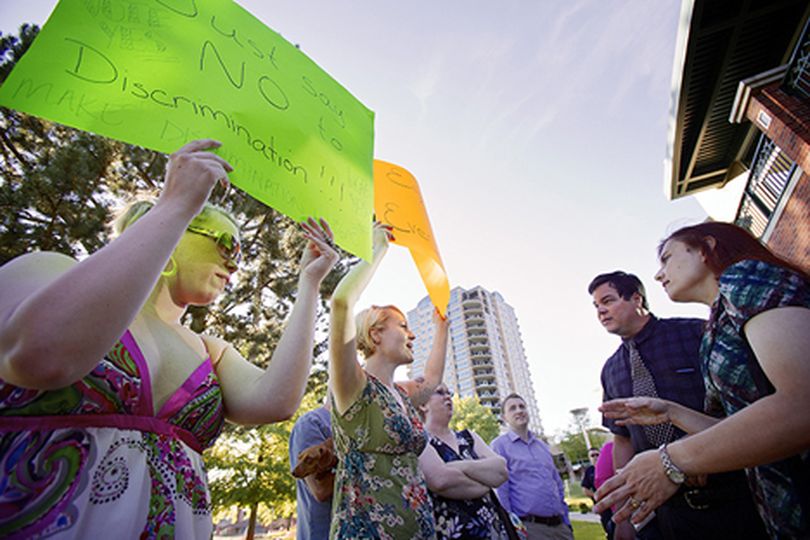 Jenny Vanderhoef, left, and Erin Lyke,��debate their position in support of non-discrimination regulations with two individuals who refused to give their names and do not support the regulations. Due to a maximum capacity of attendants to Tuesday's meeting, many had to wait outside of the city council meeting at the Coeur d'Alene Public Library until space was available in the library's community room. (Jerome Pollos/press)