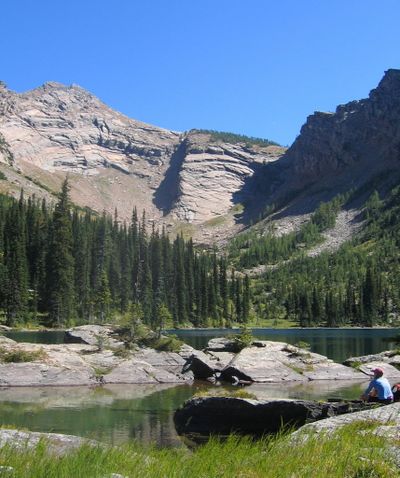 A backpacker enjoys the view of Snowshoe Lake and Snowshoe Peak in the Cabinet Mountains Wilderness, one of the original wilderness areas designated by Congress in the Wilderness Act of 1964. (Sandy Compton)