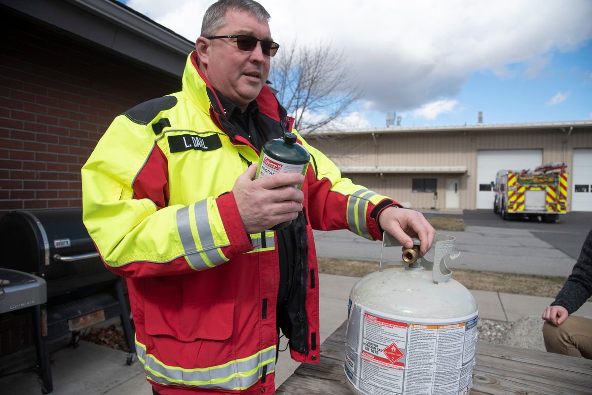 Lance Dahl, a Spokane Fire Department Fire Marshal and head of the Fire Prevention Department, explains the dangers associated with trying to refill one-pound canisters of propane from the larger tanks used on barbecues and other appliances on March 16.  (Jesse Tinsley/The Spokesman-Review)