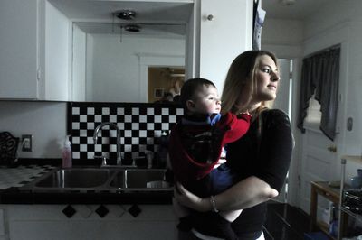 Jenna Cassidy holds her 6-month-old son, Collin,  in her Spokane home Monday. Cassidy is organizing a protest at Avista headquarters.  (Jesse Tinsley / The Spokesman-Review)