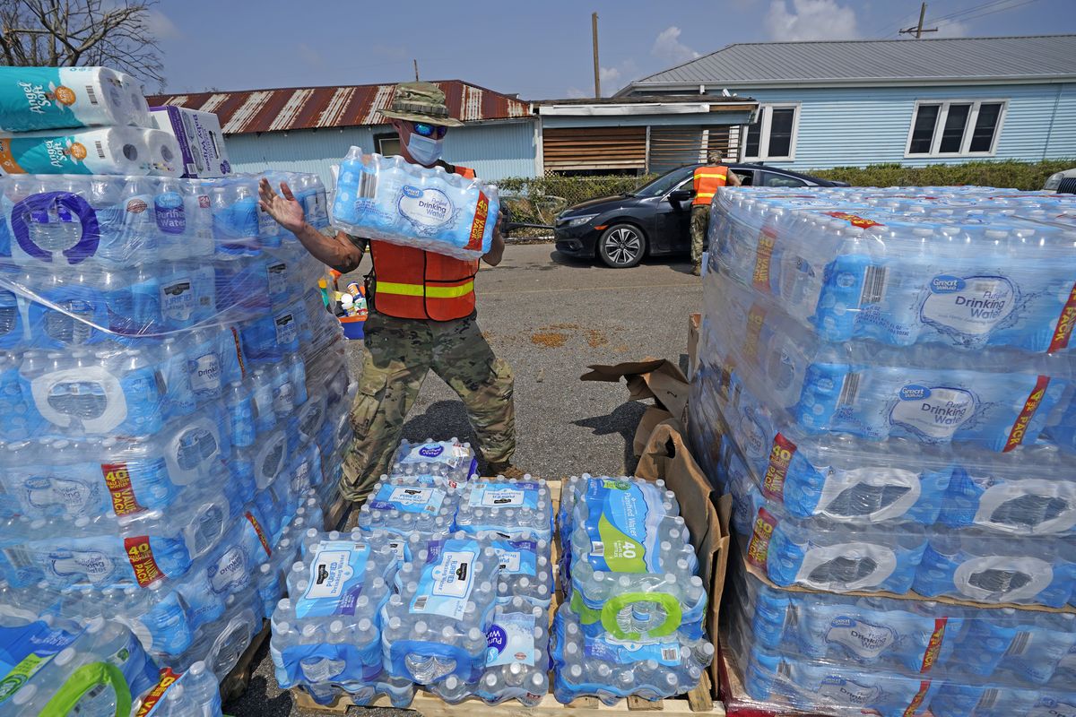Louisiana National Guard Staff Sgt. Justin Dufreche helps load water into vehicles at a distribution site, in the aftermath of Hurricane Ida, Thursday, Sept. 2, 2021, in Golden Meadow, La.  (David J. Phillip)