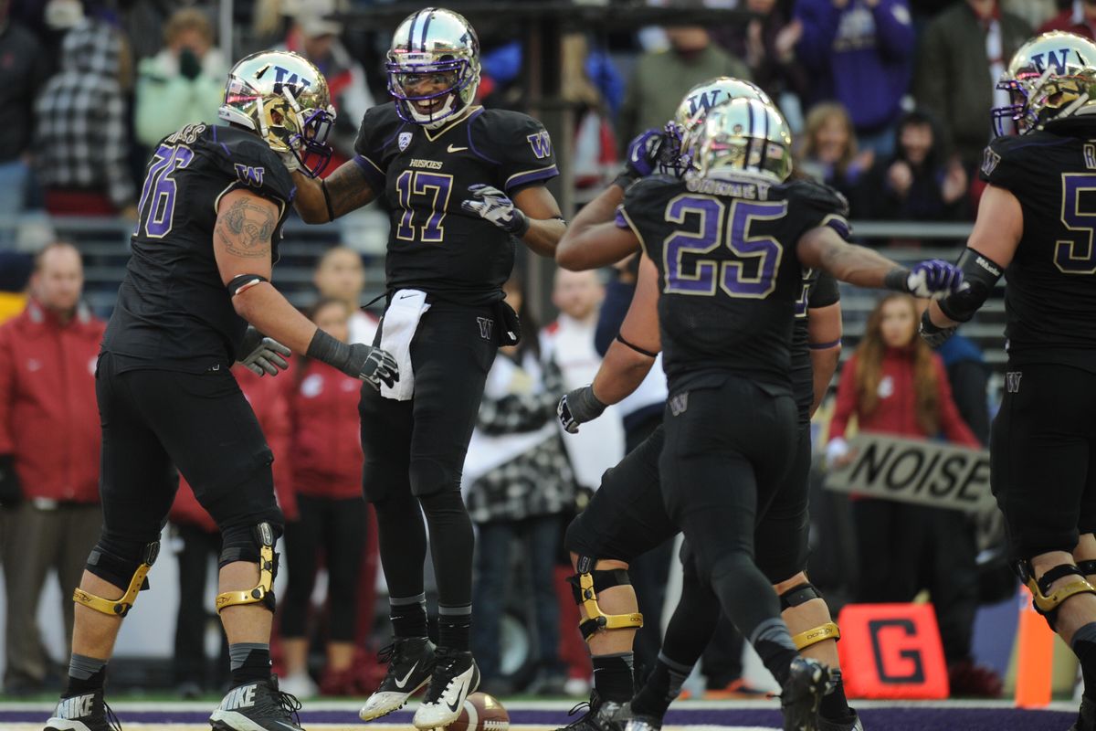 Bishop Sankey (25) runs over to celebrate with Washington quarterback Keith Price (17) after Price scored to all but clinch the victory in Friday’s Apple Cup. (Tyler Tjomsland)