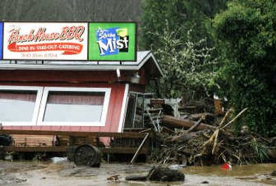 
Amy Anderson, below, right, hugs Melanie Tapia after a flash flood swept down a tributary of Kennedy Creek and tore through the Ranch House BBQ restaurant, above, near Olympia on Monday. Associated Press photos
 (Associated Press photos / The Spokesman-Review)