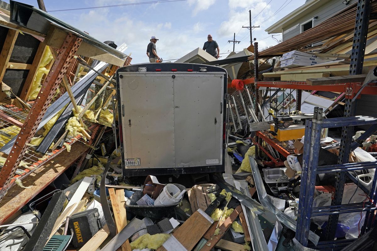 FILE - In this Monday, Aug. 30, 2021, file photo, Jacob Hodges, right, and his brother Jeremy Hodges work to clear debris from their storage unit which was destroyed by Hurricane Ida, in Houma, La. A new report from the United Nations weather agency finds the world is getting several times more weather disasters than in the 1970s.  (David J. Phillip)