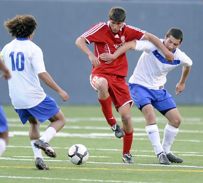 Mead’s Nick Hamer, left, and Spencer Button, right, clamp down on Ferris’ Alec Cutter at Albi Stadium on Tuesday. (Jesse Tinsley)