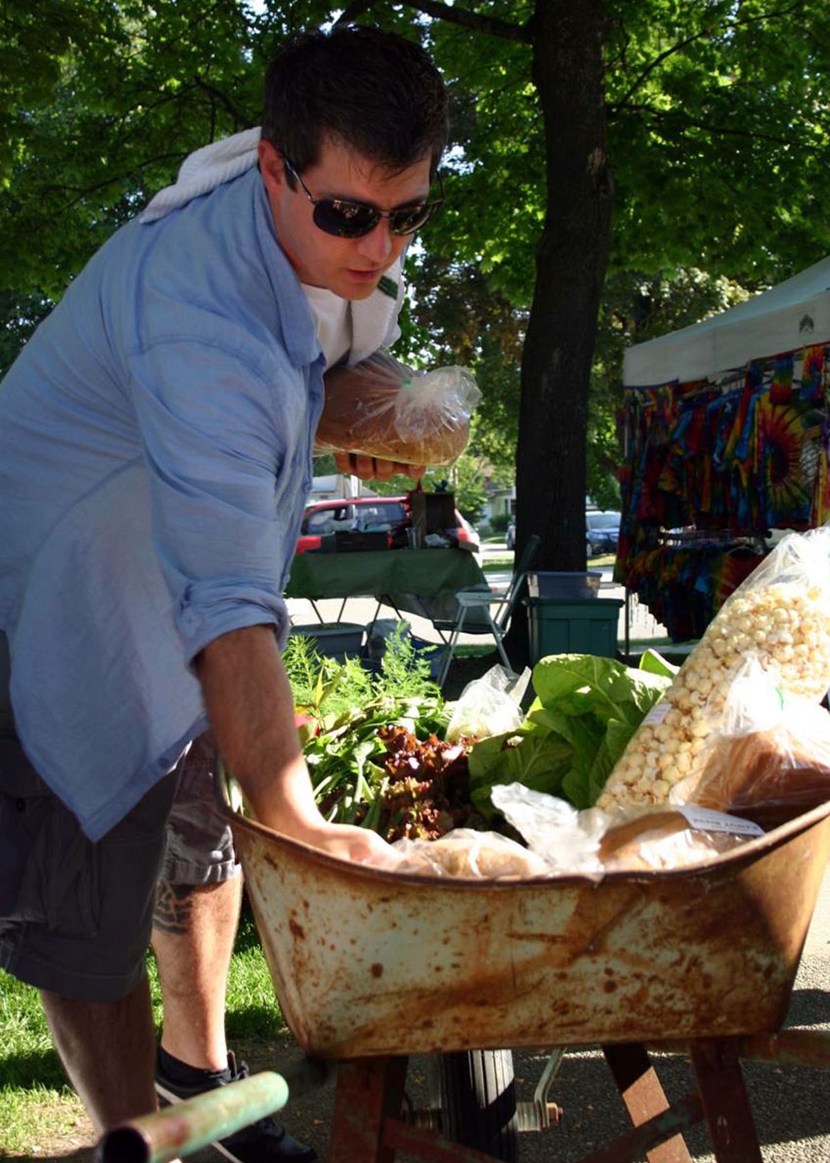 Chef Jeremy Hansen of Santé Restaurant and Charcuterie puts bread into a wheelbarrow at the Wheelbarrow Wednesday event at the Sandpoint Farmers Market. Dinner guests followed Hansen to the farmers market where he filled a wheelbarrow with ingredients for a meal served at Pend d’Oreille Winery for the farm-to-fork dinner.