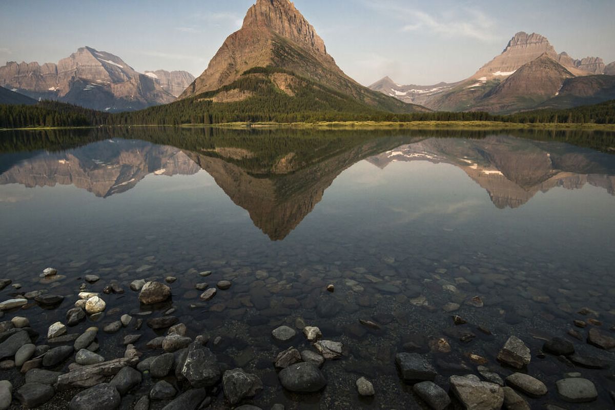 Grinnell Peak is reflected in the still waters of Swiftcurrent Lake at Many Glacier. Mt. Gould is to the left and Mt. Wilbur is to the right.  (Courtesy of National Park Service )