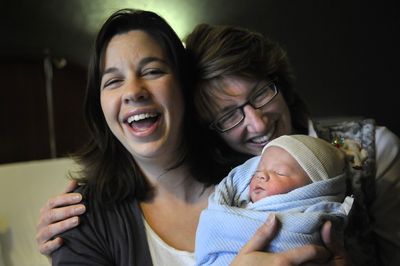 Zibby Merritt and her newborn son, Tyler, gather with midwife Kathy Bentley, right, Dec. 12  at Deaconess Medical Center nine hours after the boy was born. Tyler is the 1,000th baby delivered by Bentley.  (Dan Pelle / The Spokesman-Review)
