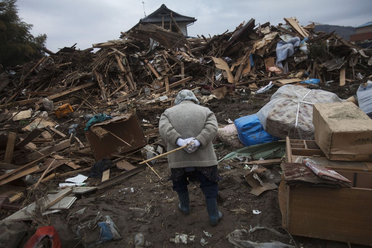 An elderly Japanese woman searches for her belongings in the March 11 earthquake and tsunami-destroyed town of Rikuzentakata, northeastern Japan, on Monday. (Associated Press)