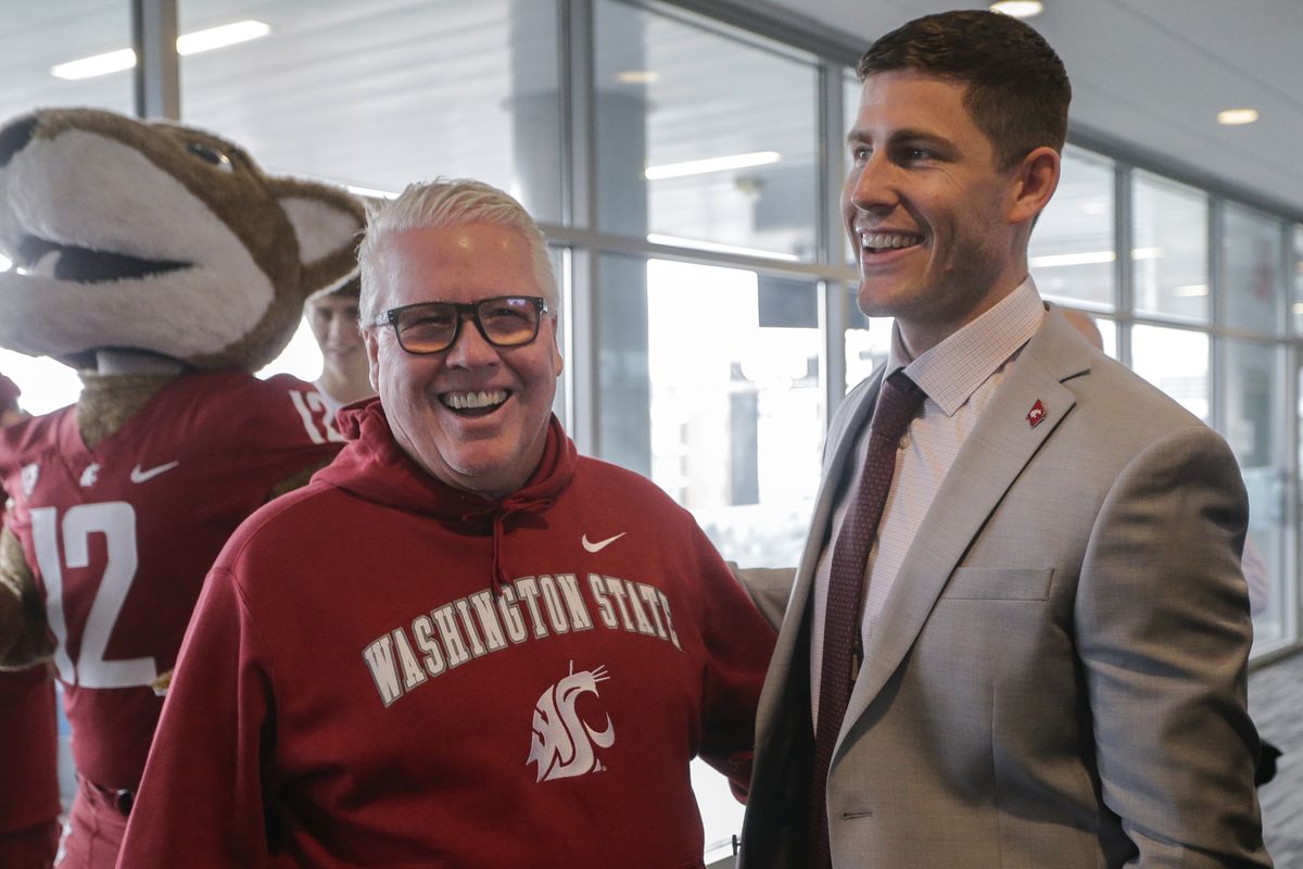 At left: Kirby Moore, right, talks with his father, Tom Moore, after he was introduced as Washington State University’s new head football coach on Tuesday in Pullman. Below: Kirby Moore runs with a catch while playing at Boise State.  (Geoff Crimmins/For The Spokesman-Review)