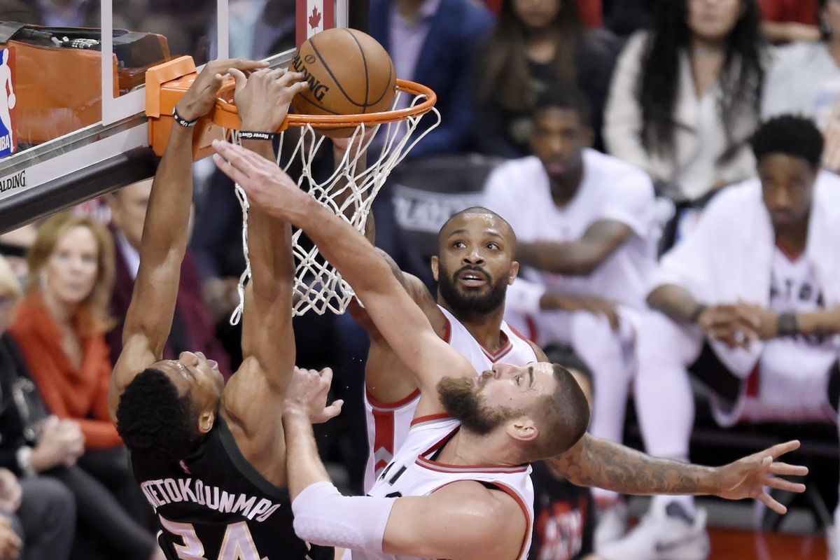 Milwaukee Bucks forward Giannis Antetokounmpo, left, dunks the ball past Toronto Raptors forward PJ Tucker, back center, and center Jonas Valanciunas during the second half in Game 5 of a first-round NBA basketball playoff series in Toronto on Monday, April 24, 2017. (Nathan Denette / Associated Press)
