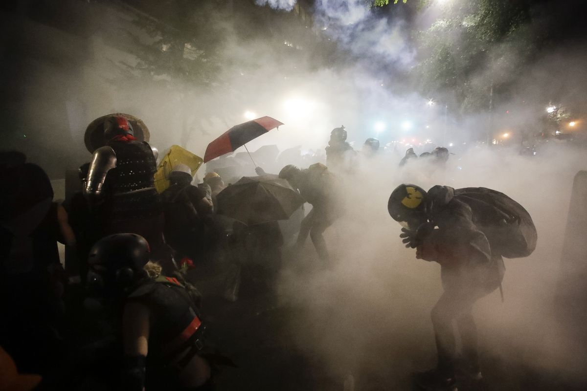 Federal officers launch tear gas at a group of demonstrators during a Black Lives Matter protest at the Mark O. Hatfield United States Courthouse Sunday, July 26, 2020, in Portland, Ore.  (Marcio Jose Sanchez)