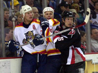 
Buffalo's Toni Lydman checks Florida's Chris Gratton, left, and Olli Jokinen during first-period play on Sunday.
 (Associated Press / The Spokesman-Review)