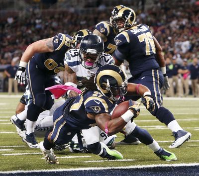 Rams running back Tre Mason dives into the end zone past Seahawks safety Earl Thomas for his first NFL touchdown. (Associated Press)