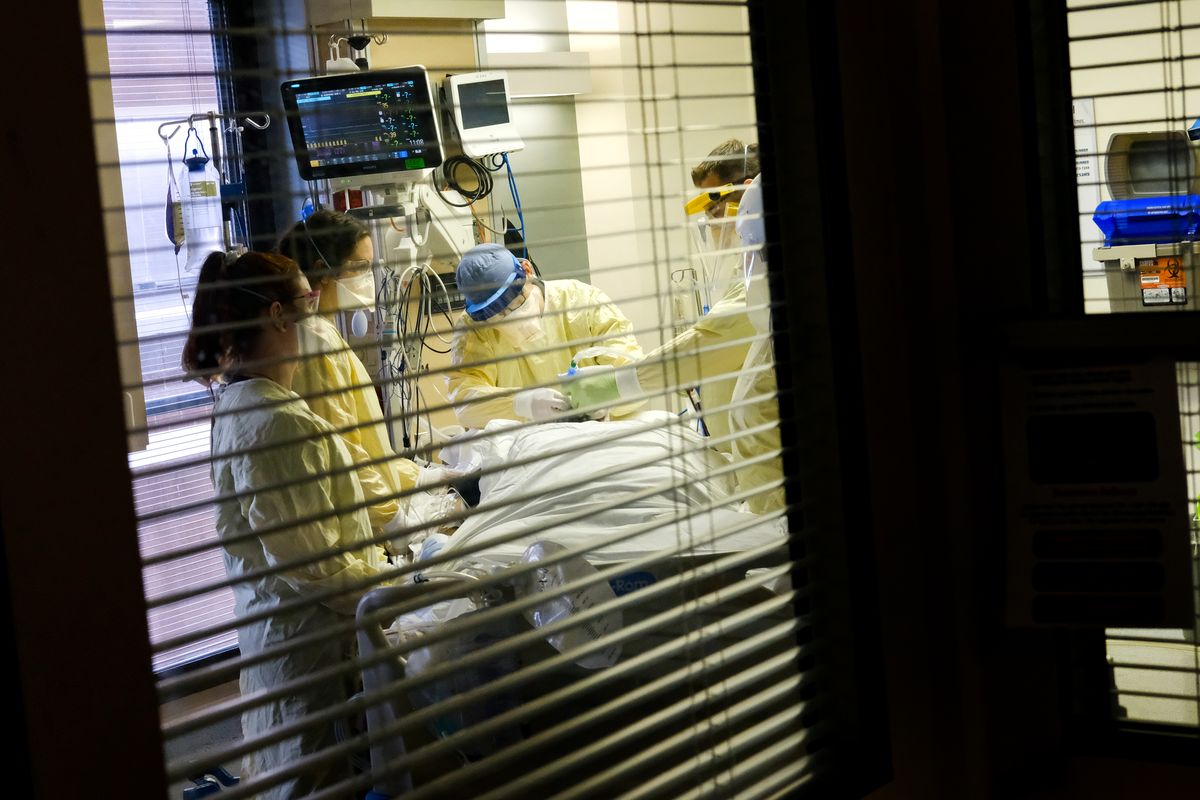 Hospital staff adjust a COVID-19 patient’s ventilator tube before they rolled the patient from their back to the prone position on earlier this year at MultiCare Deaconess Hospital’s ICU. While hospitalizations in Washington have hit a plateau, that plateus is at a lofty altitude - roughly 1,000 patients a day.   (Tyler Tjomsland/The Spokesman-Review)