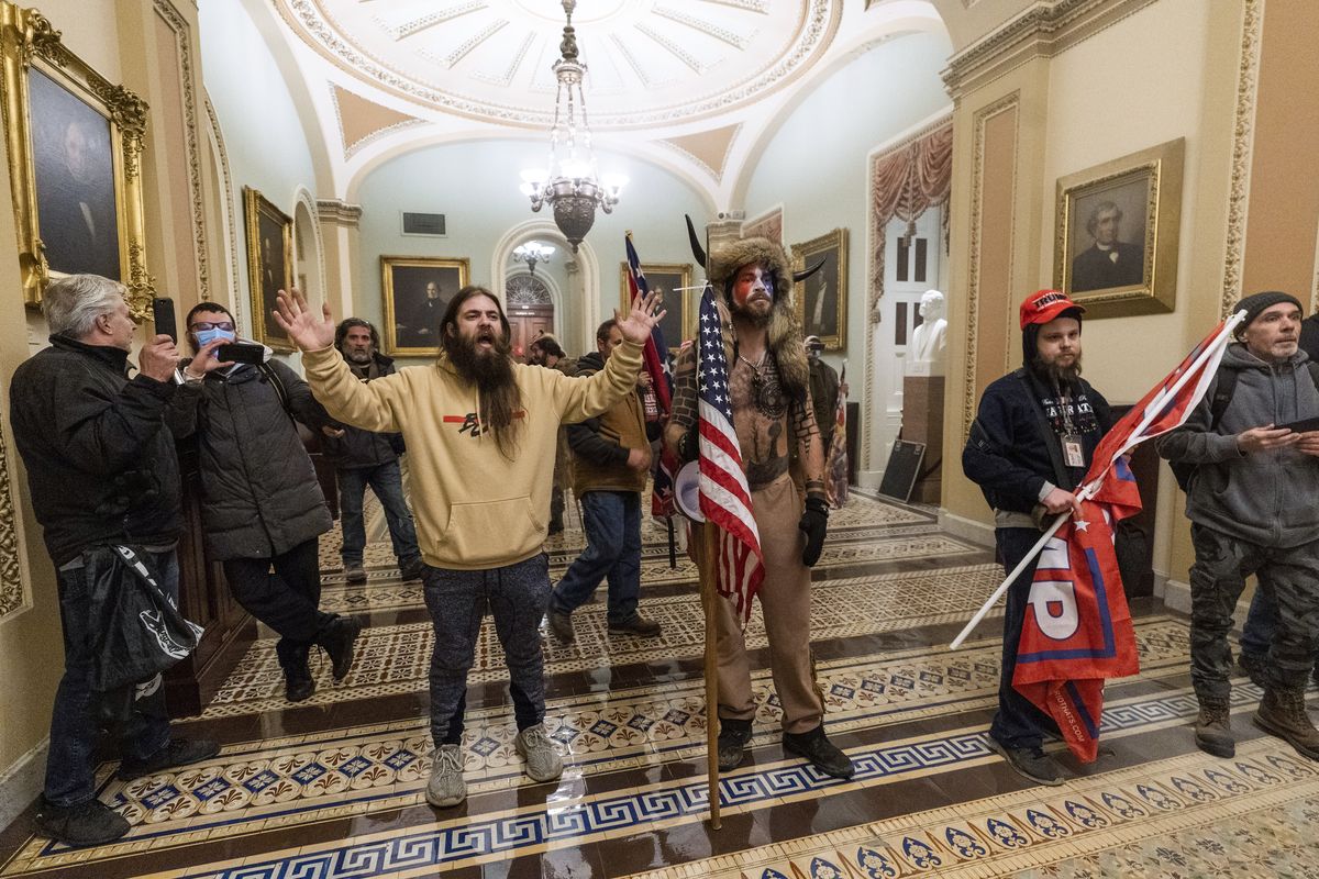 FILE - In this Wednesday, Jan. 6, 2021 file photo supporters of President Donald Trump are confronted by U.S. Capitol Police officers outside the Senate Chamber inside the Capitol in Washington. Jacob Anthony Chansley, the Arizona man with the painted face and wearing a horned, fur hat, was taken into custody Saturday, Jan. 9, 2021 and charged with counts that include violent entry and disorderly conduct on Capitol grounds. (Manuel Balce Ceneta)