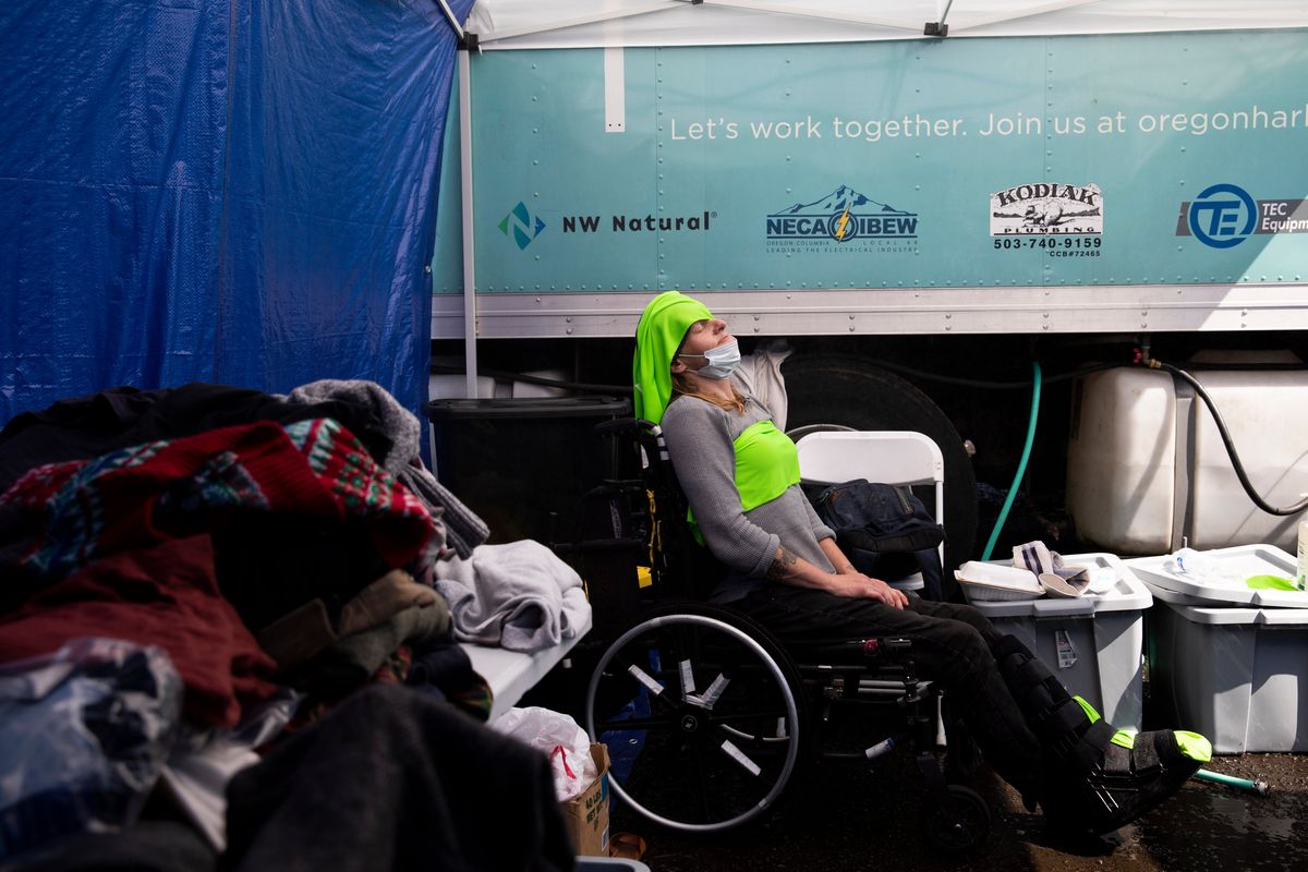 Tracy Wallace puts ice-cold cloths on her forehead and chest to stay cool at the Sunrise Center cooling center in Portland during a record-breaking heat wave on June 27, 2021.  (Alisha Jucevic/For The Washington Post)