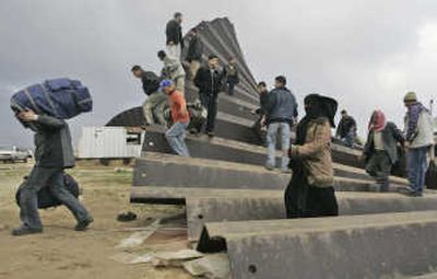 
Palestinians cross the border Wednesday into Egypt after militants leveled the wall on the Gaza Strip border.
 (Associated Press / The Spokesman-Review)