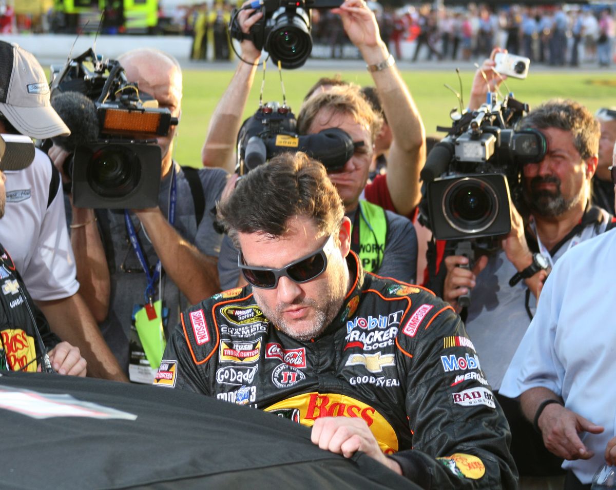Tony Stewart climbs into his car to start Sunday’s race, his first since being involved in a fatal racing accident. (Associated Press)