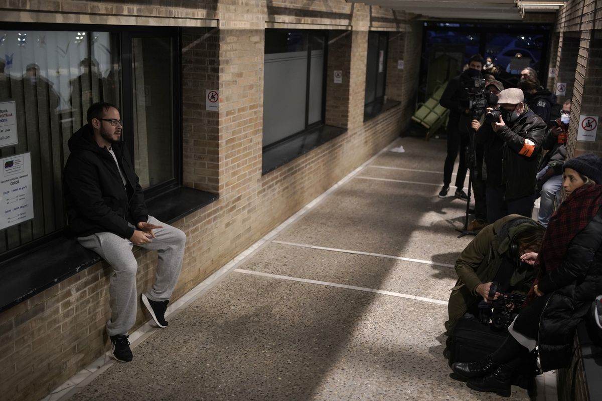 Rap singer Pablo Hasél sits inside the University of Lleida, Spain, Monday, Feb. 15, 2021. A rapper in Spain and dozens of his supporters have locked themselves inside a university building in the artist