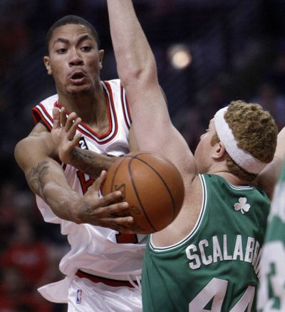 The Bulls’ Derrick Rose, left, passes around the Celtics’ Brian Scalabrine during the first half of Game 4 in Chicago. (Associated Press / The Spokesman-Review)