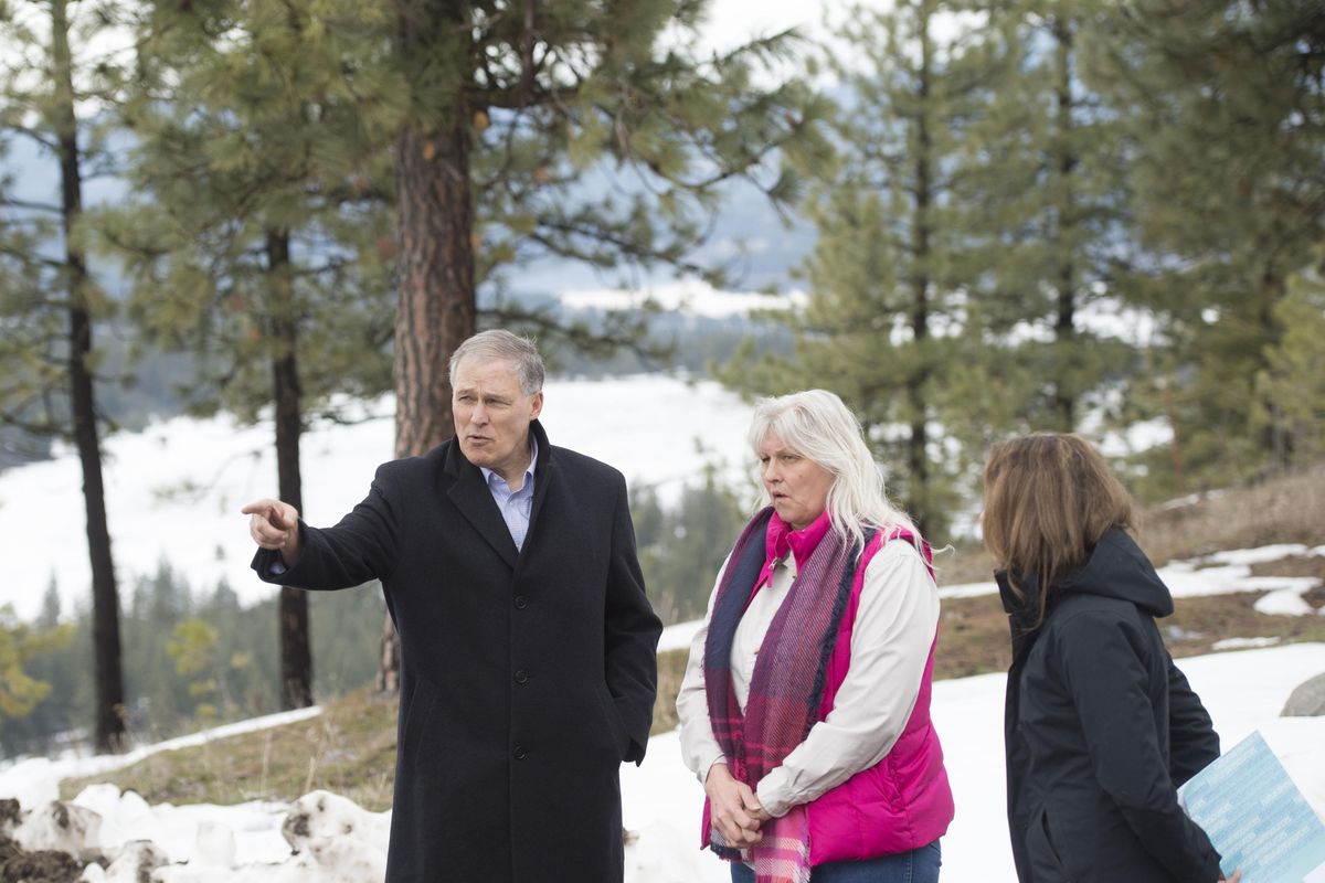 Gov. Jay Inslee visits with Bonnie Cobb, a Firestorm survivor during a tour of her property showing how Spokane County has dealt with the impact of wildfires, on Tuesday, March 14, 2017, at in Nine Mile Falls, Wash. (Tyler Tjomsland / The Spokesman-Review)