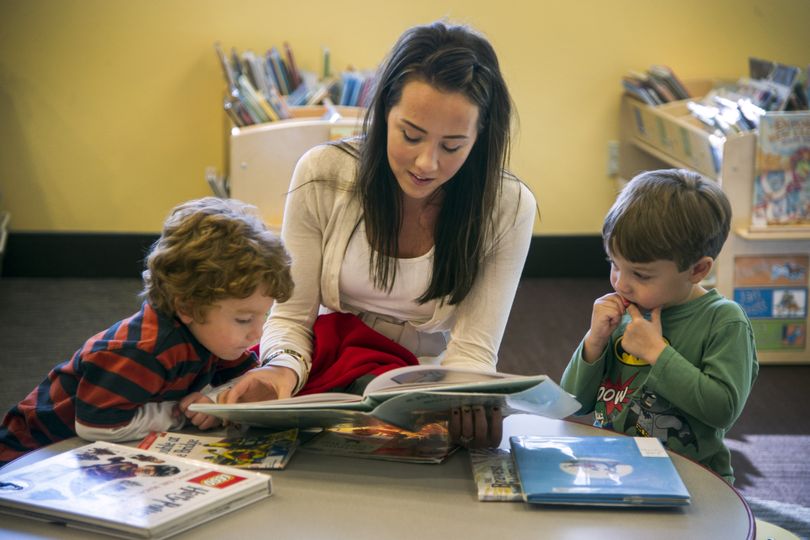 Kate Steen, nanny for twins Reed Swain, left and Harrison Swain, age 3, reads to them at the Liberty Lake Library Tuesday. When the city of Liberty Lake incorporated, it started it’s own library rather than contract with the Spokane County Library District. Now the two agencies are forming a partnership. (Colin Mulvany)