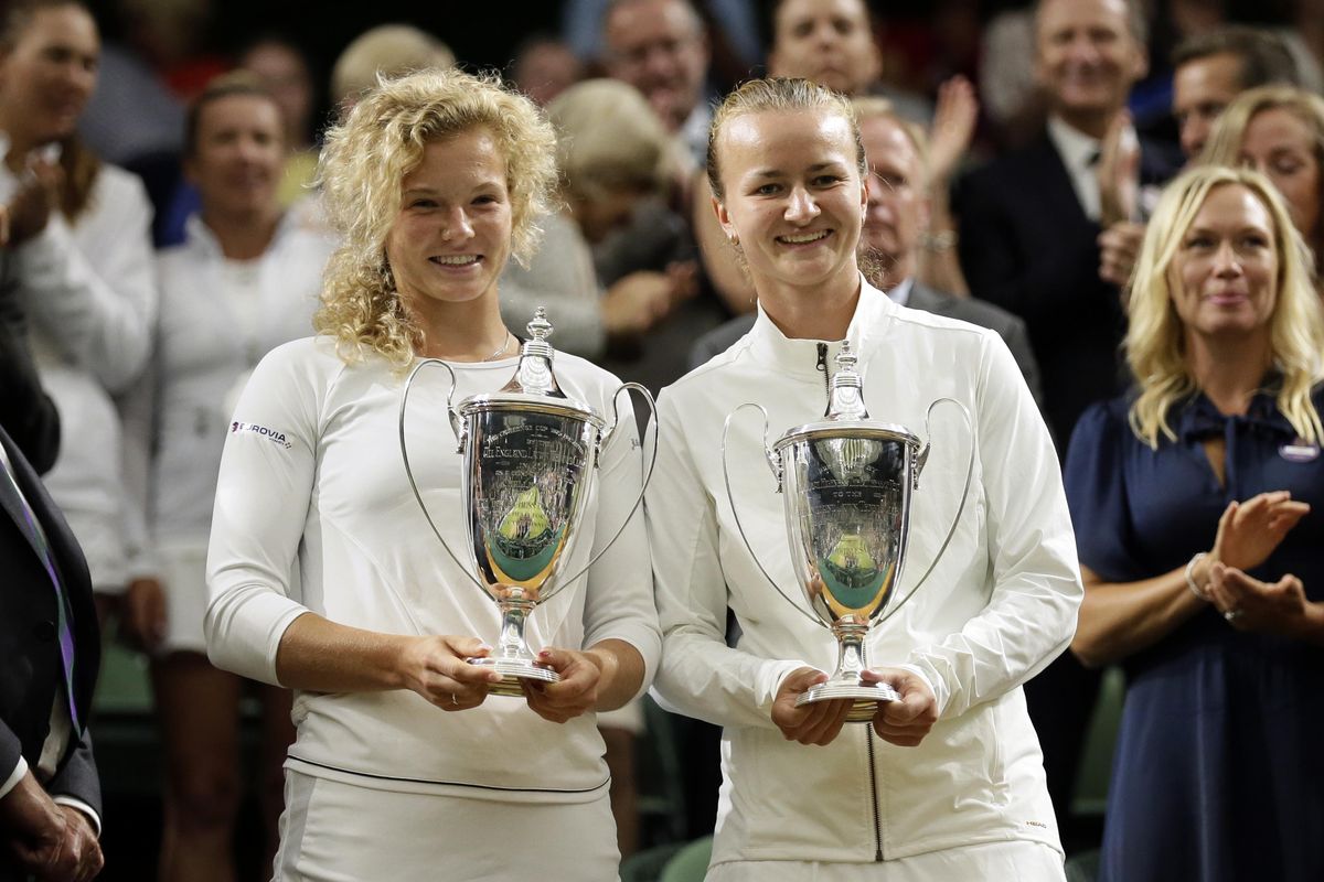 Katerina Siniakova of the Czech Republic, left, and Barbora Krejcíkova of the Czech Republic hold up their trophies after defeating Nicole Melichar of the US and Kveta Peschke of the Czech Republic in their women’s doubles final match at the Wimbledon Tennis Championships in London, Saturday July 14, 2018. (Tim Ireland / Associated Press)