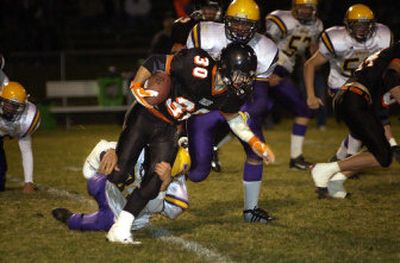 
Post Falls fullback Bobby Kuber (30) is tripped up by Lewiston's Ethan Monroe as the Bengals bottled up the Trojan in a 35-14 victory Friday night.
 (Tom Davenport/ / The Spokesman-Review)