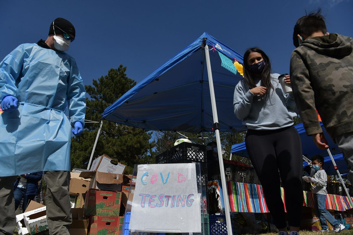 El Mercadito and WSU’s Range Clinic staff members set up signs advertising COVID-19 testing at the Range Mobile clinic adjacent to the market on Saturday.  (Tyler Tjomsland/The Spokesman-Review)