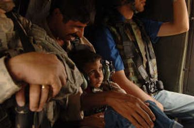 
Ihaab, a 5-year-old Iraqi boy born with a congenital defect, sits in the lap of his father, Najim Mohammed, in a U.S.  Black Hawk helicopter Oct. 8 at Forward Operating Base Hammer, Iraq. Associated Press
 (Associated Press / The Spokesman-Review)