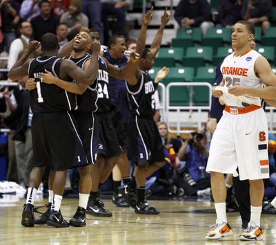 It’s not a pretty sight for Syracuse’s Brandon Triche as Butler players celebrate their Sweet 16 win.  (Associated Press)